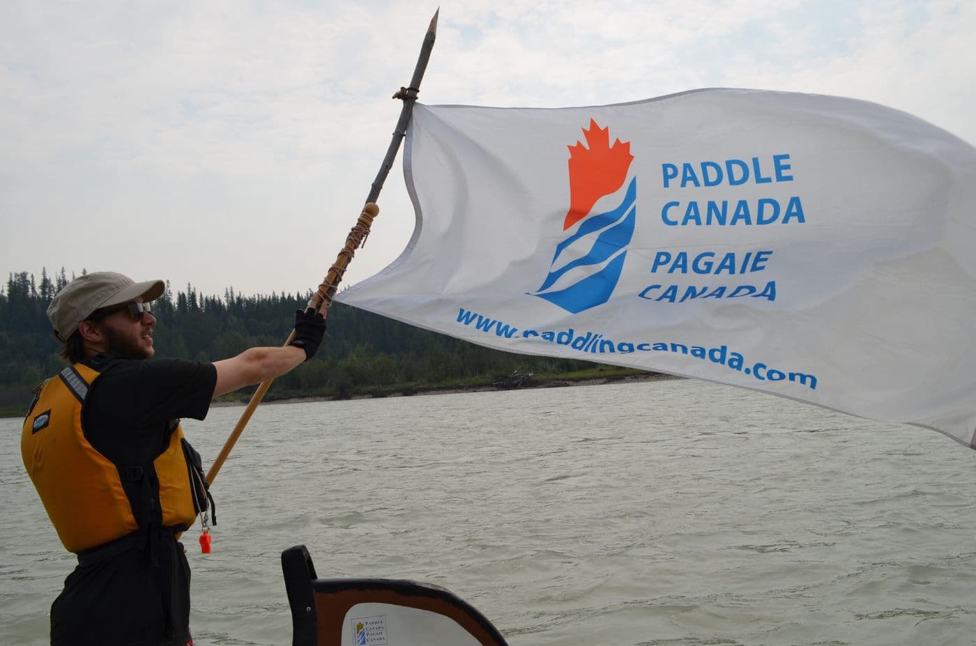 A man holding the Paddle Canada flag.