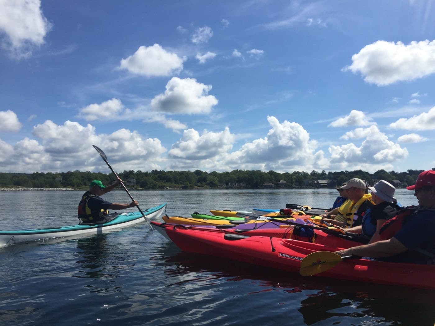 A lady and a dog sitting in a tent overlooking the water.
